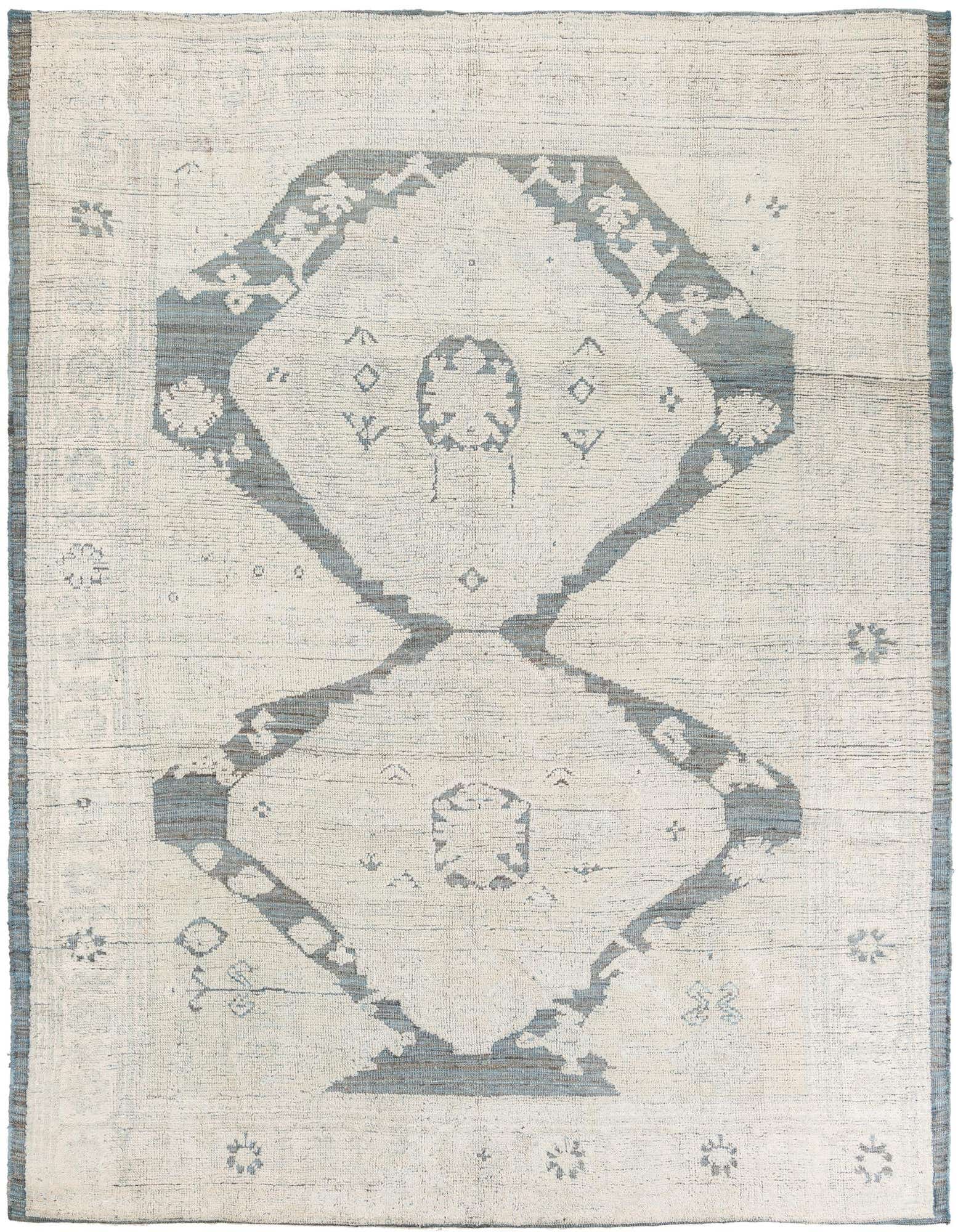 An 8x10 rectangular ivory shag rug with a large, faded blue-gray tribal medallion pattern, suitable for a living room.