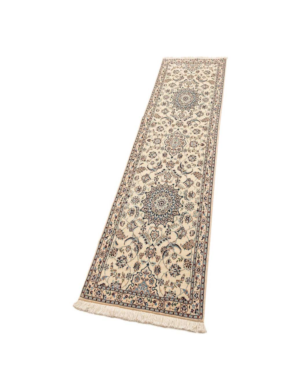 A 4x6 rectangular ivory wool rug with intricate blue and beige traditional patterns, featuring fringe on the ends.