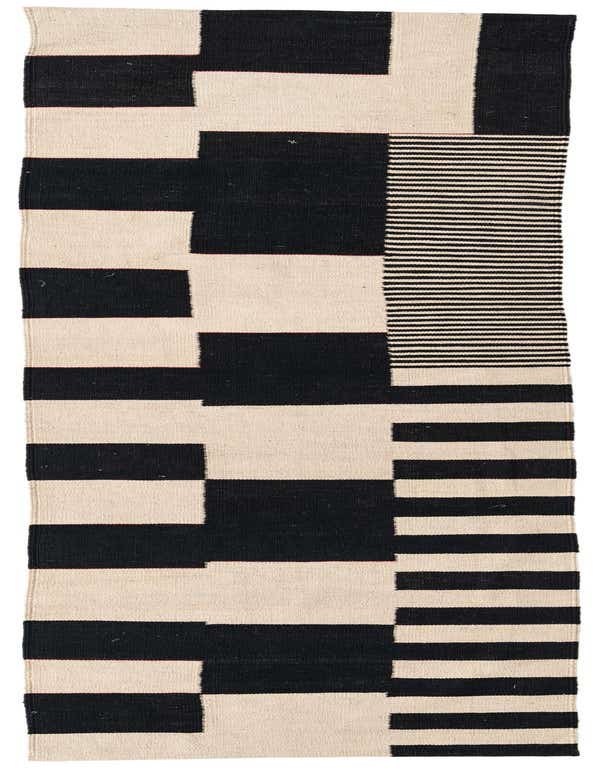 A 10 ft runner rug with a modern tribal pattern in black and ivory, featuring bold geometric blocks and thin horizontal stripes.
