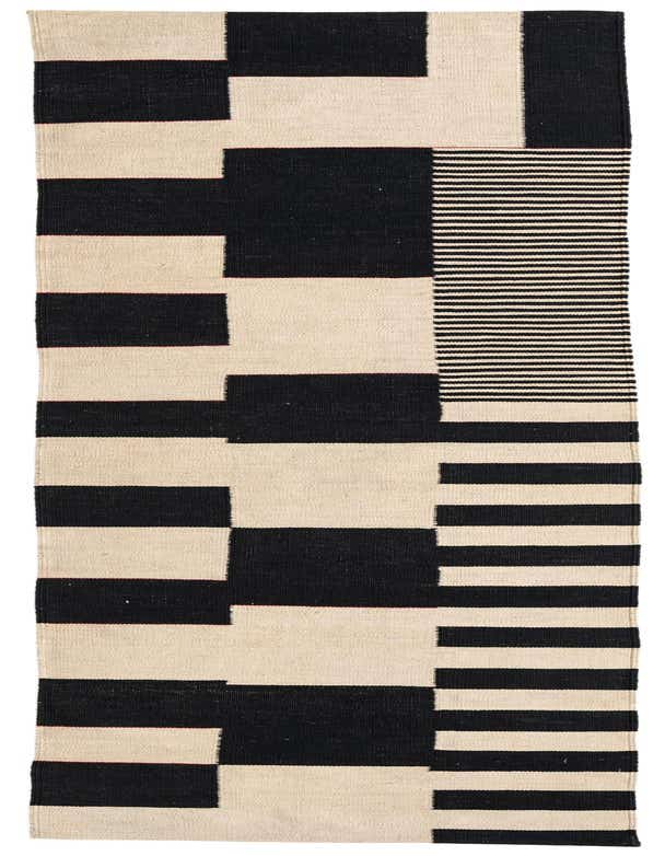 A 10 ft runner rug with a modern tribal pattern in black and ivory, featuring bold geometric blocks and horizontal stripes.