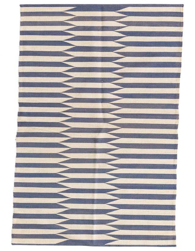 A 10 ft runner rug featuring a modern tribal pattern of alternating ivory and blue horizontal stripes with a serrated edge.