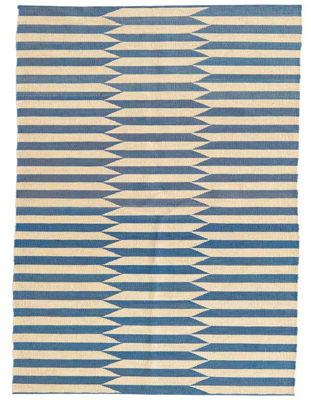 A 10 ft runner rug featuring a tribal geometric pattern of alternating blue and cream horizontal stripes, with jagged edges creating a dynamic, modern look.