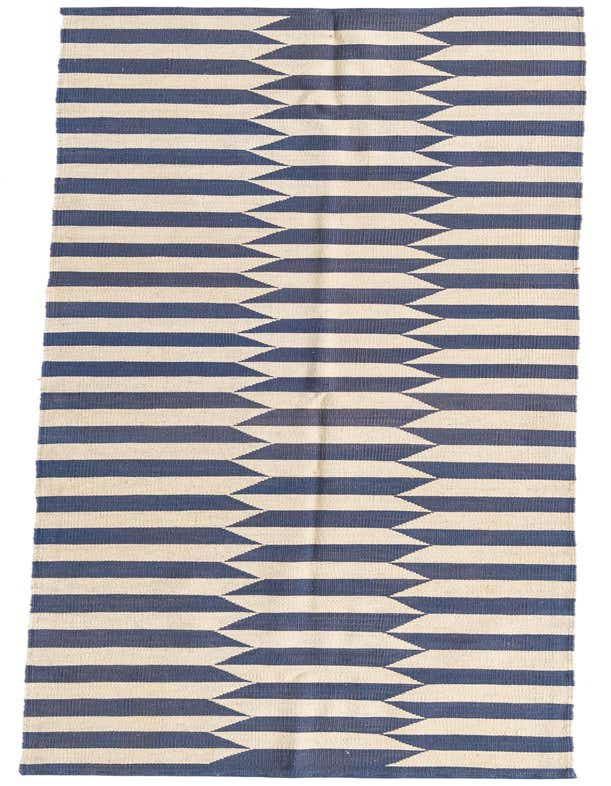 A 10 ft runner rug featuring a modern tribal pattern of alternating navy blue and ivory horizontal stripes with a jagged, interlocking design down the center.