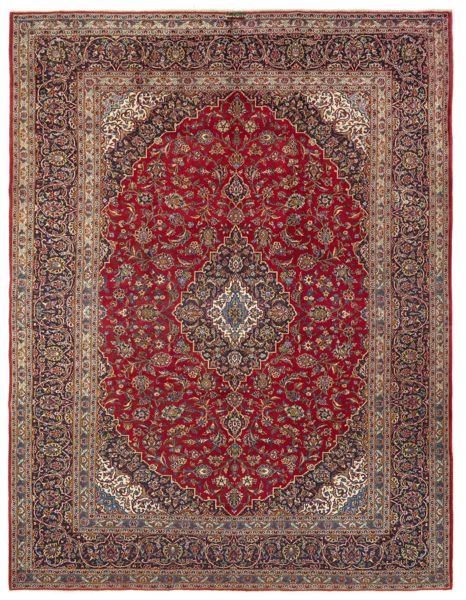 A rectangular 9x12 Kashan Persian rug with a red field, intricate floral motifs, and a dark blue border.