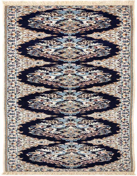 A rectangular handmade Persian rug with a deep blue background and intricate floral patterns in light blue, cream, and tan, featuring fringed ends.