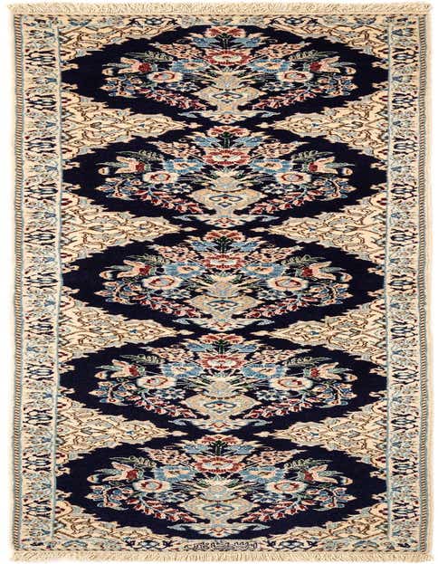 A handmade rectangular Nain Persian rug featuring a deep blue field with intricate floral motifs and a light cream border.