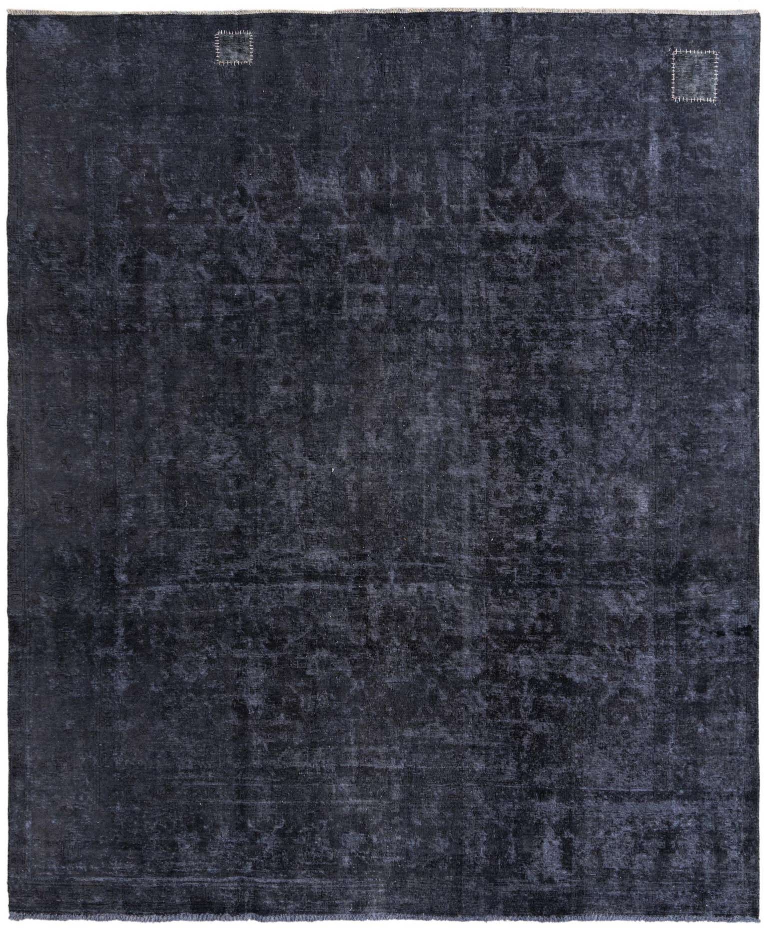 A large 9x11 rectangular indoor rug in varying shades of dark blue, featuring a subtle distressed Persian-style pattern and two small light-colored patches.