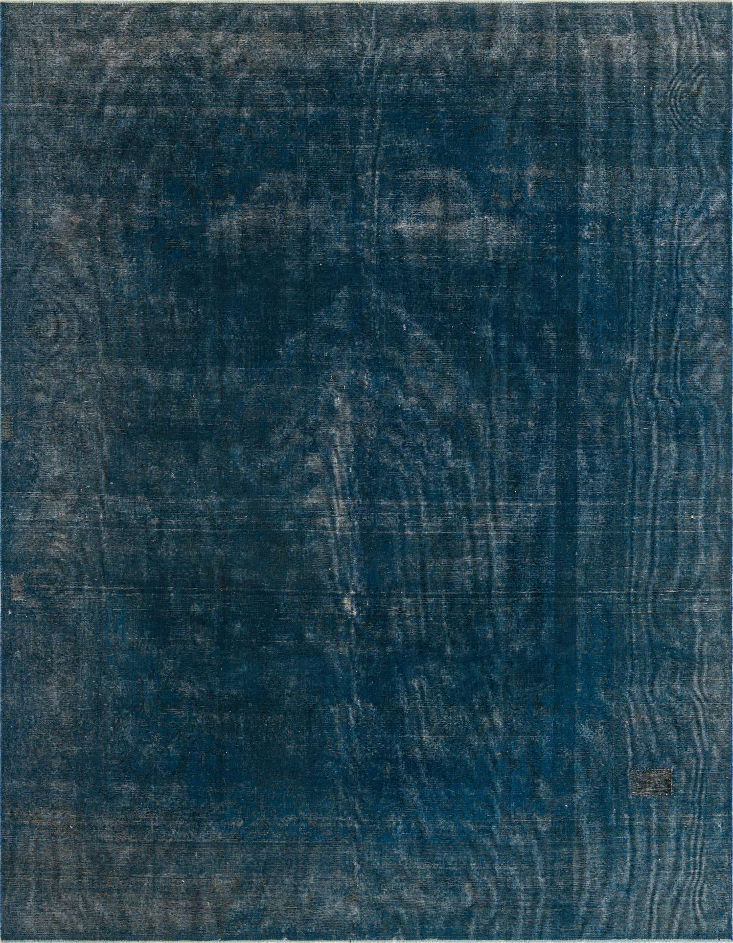 A 10x13 rectangular blue wool area rug with a subtle, faded vintage Persian medallion pattern, suitable for a living room.