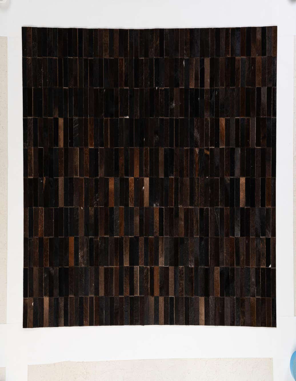 A 5x8 rectangular Cowhide Patchwork rug featuring a modern pattern of varying brown and tan leather rectangles.