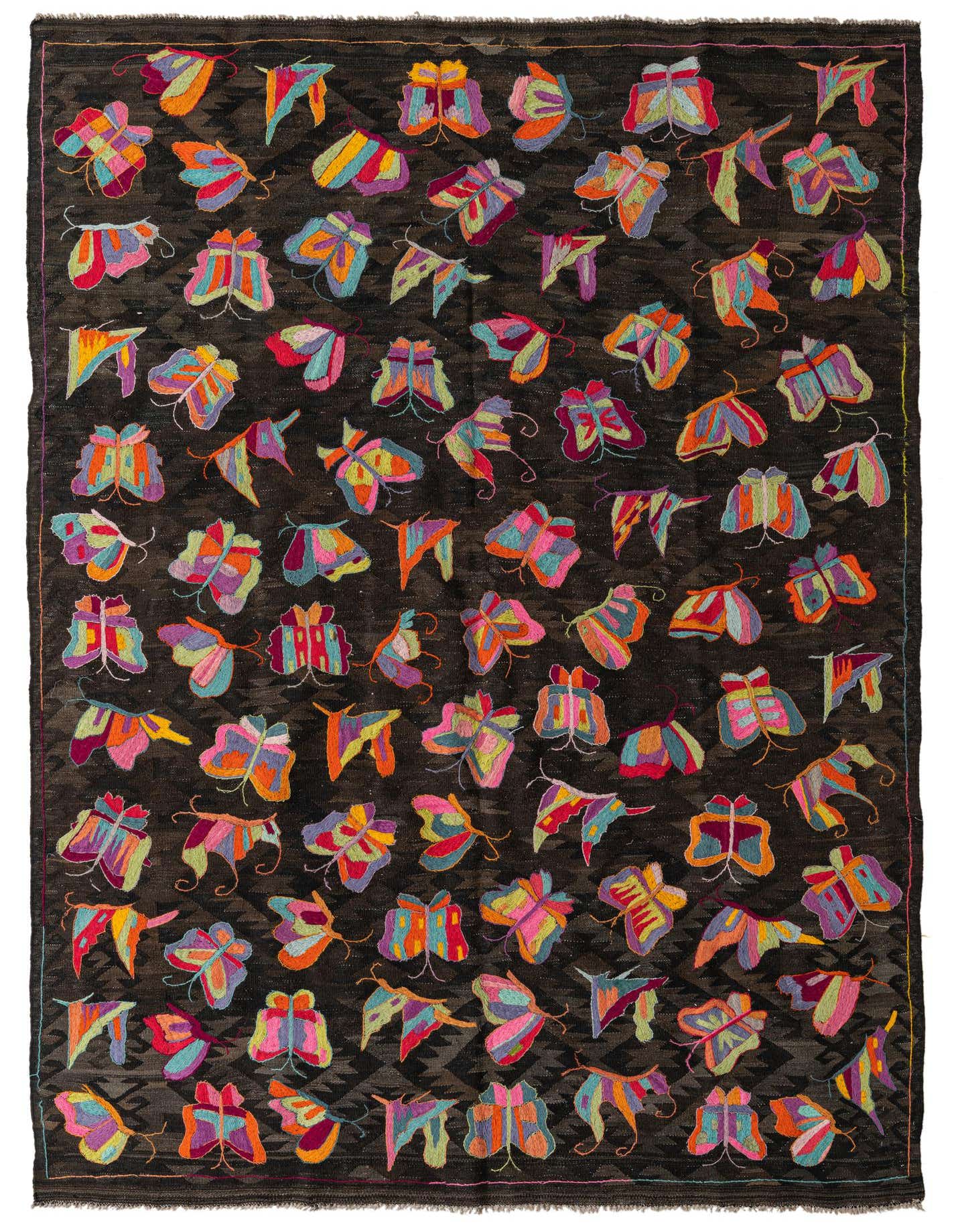 A 7x10 rectangular flatweave rug with a dark brown background and a scattered pattern of colorful, abstract butterflies in various bright hues.
