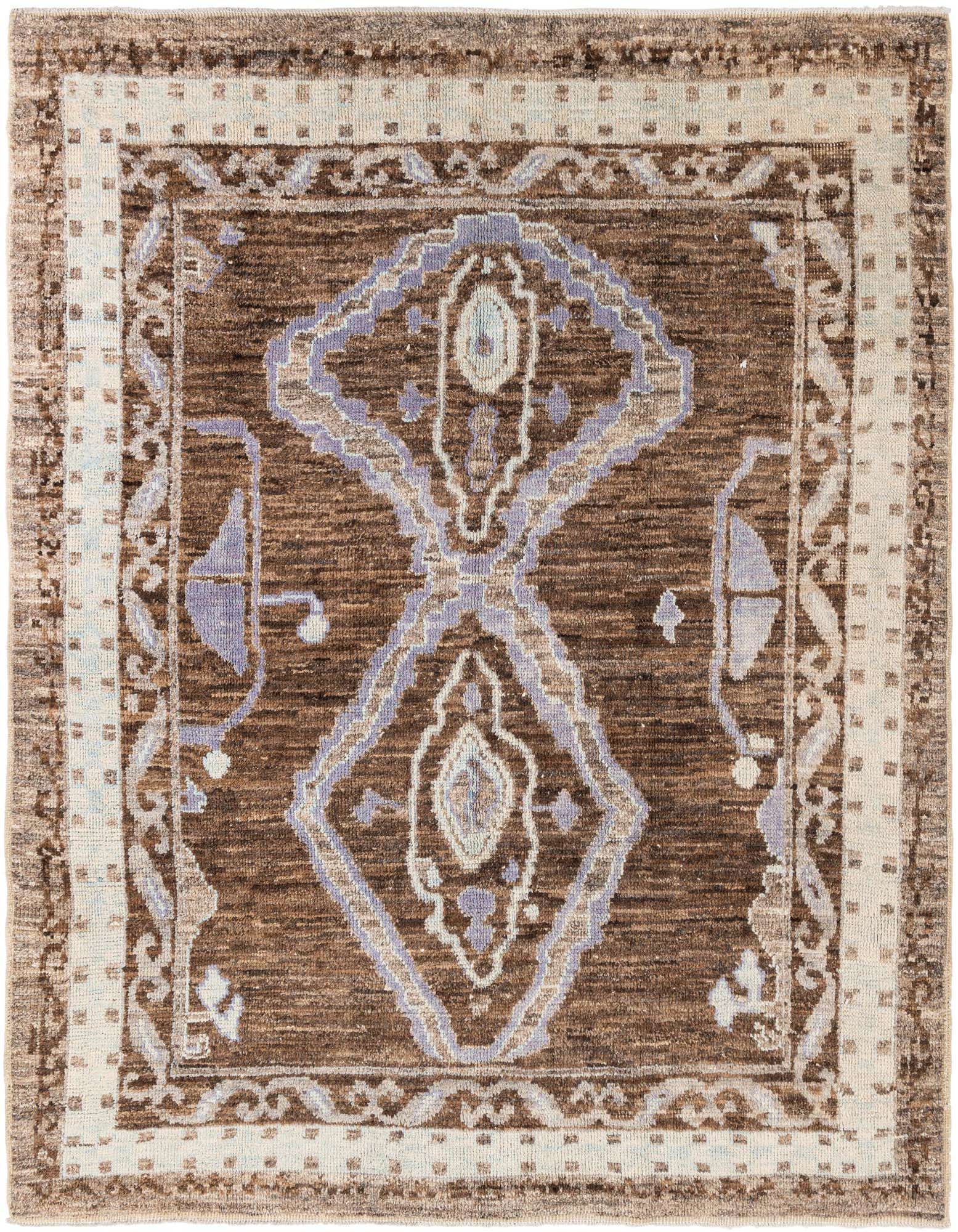 A rectangular 8x10 brown shag rug with a central medallion and tribal patterns in tan and light purple, suitable for a living room.