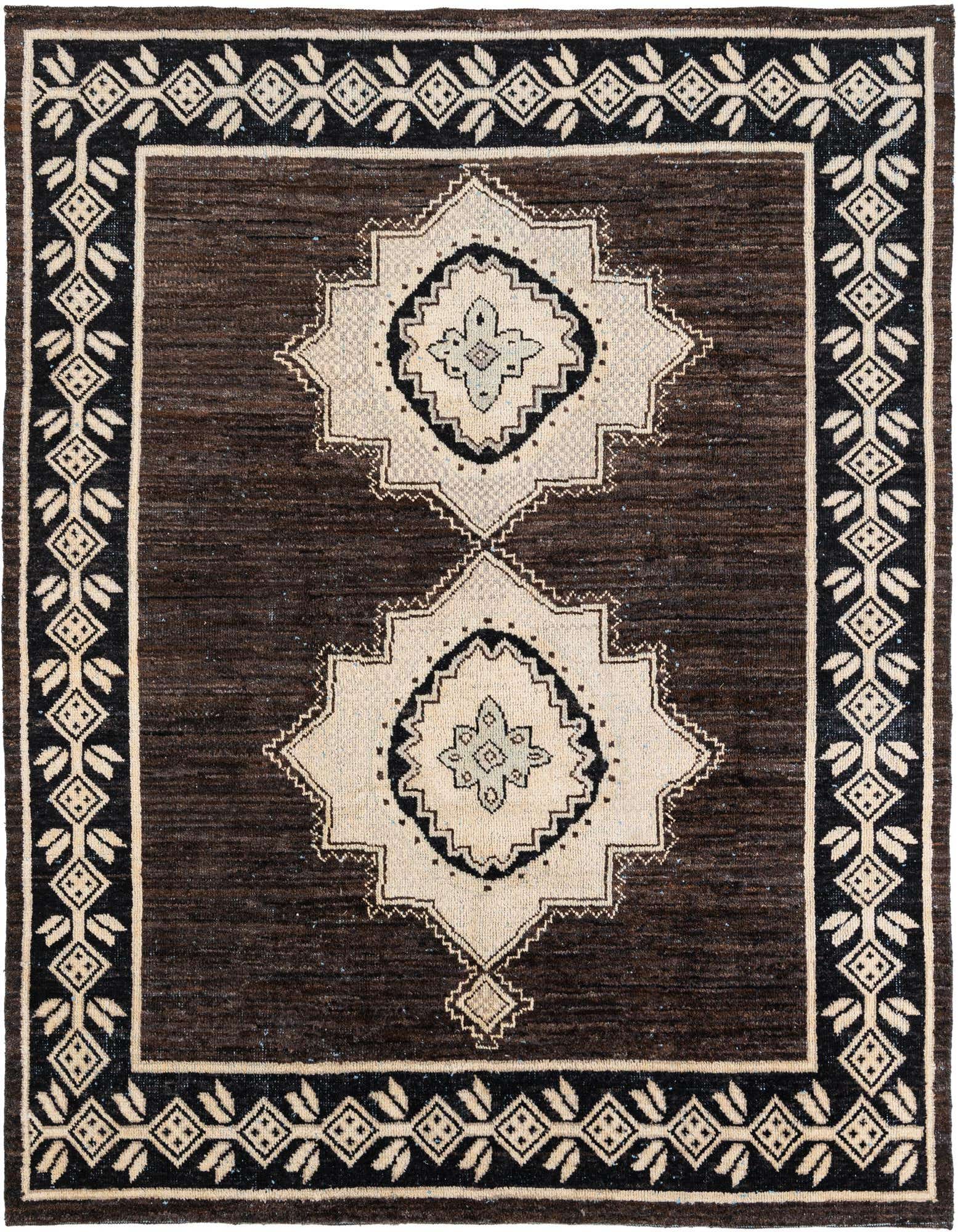 An 8x10 rectangular brown wool shag rug with two large tan and black tribal medallions and a decorative border.