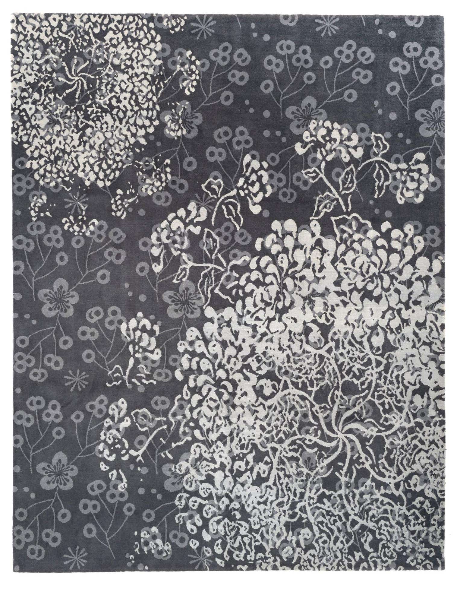 A dark grey 8x10 rectangular wool rug featuring an abstract Persian-modern floral pattern in white and light grey.