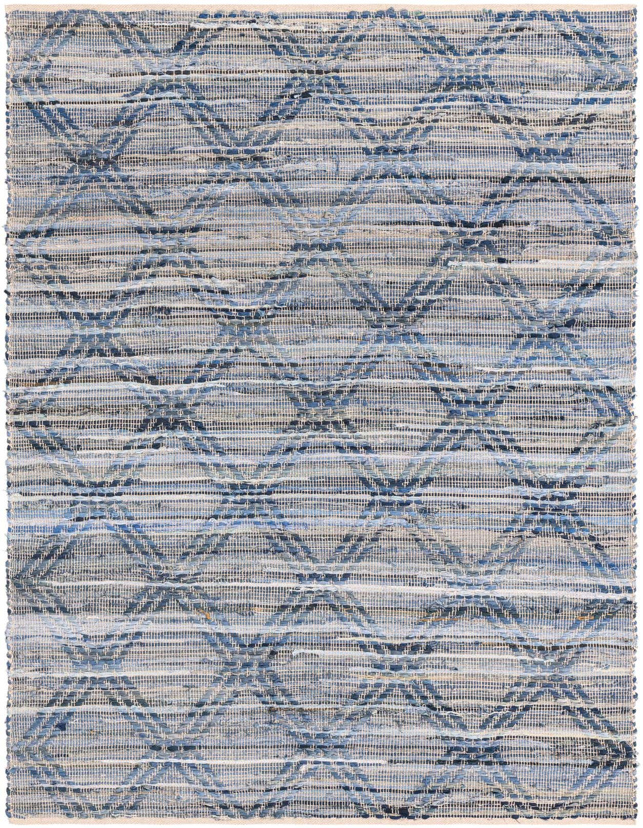 A 5x8 rectangular denim blue cotton flatweave rug with a subtle geometric pattern, suitable for a living room.