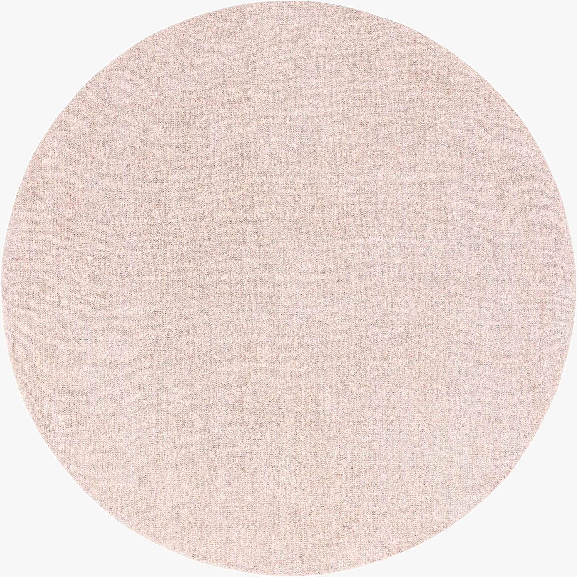 A 6' 11 x 6' 11 round Jill Zarin English Manor rug in a soft pink hue, featuring a textured, solid modern design.