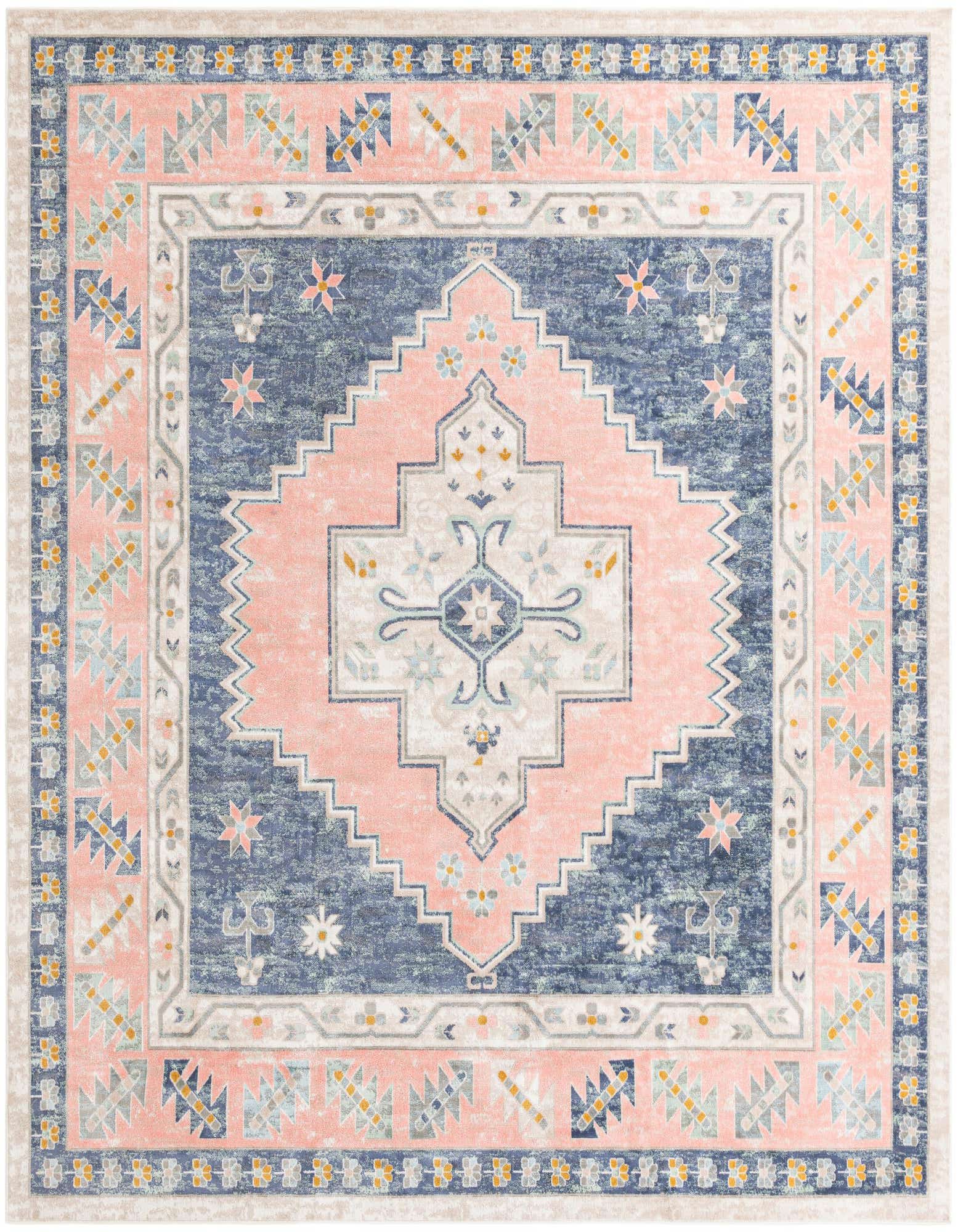 A 12' square Rugs.com Whitney rug featuring a distressed blue medallion and tribal patterns on a pink and cream background.