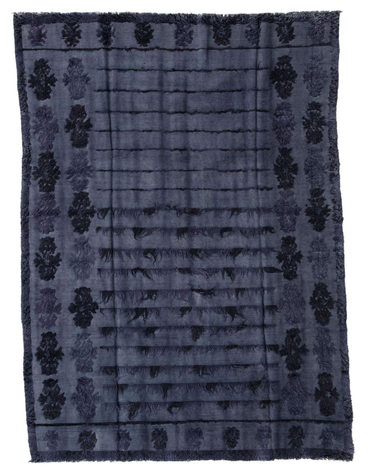 A 7x10 rectangular gray wool rug with a modern abstract pattern and textured pile, featuring dark gray horizontal lines and ornate border motifs.