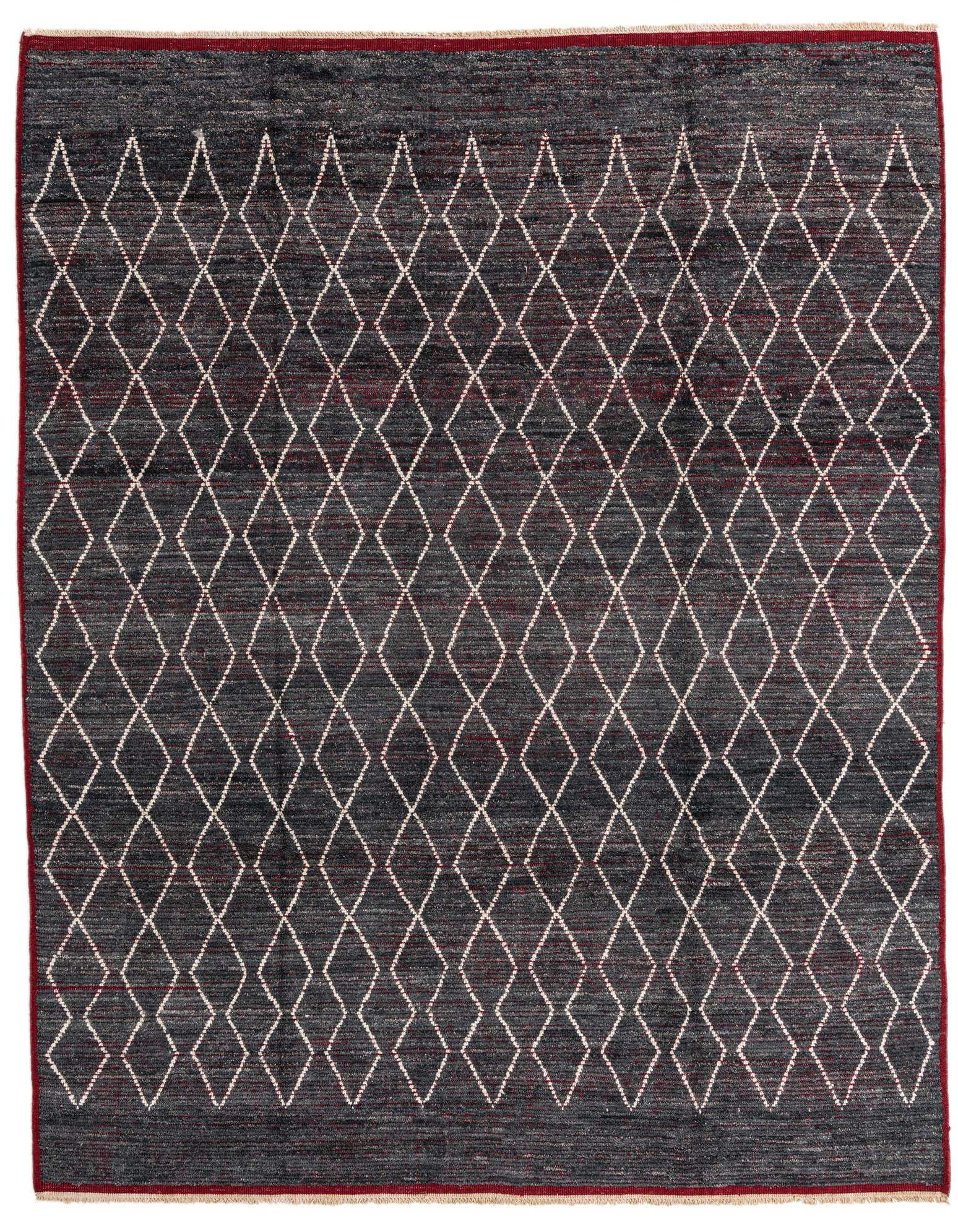 A rectangular 8x11 gray wool shag rug with a repeating white diamond tribal pattern and a thin red border.