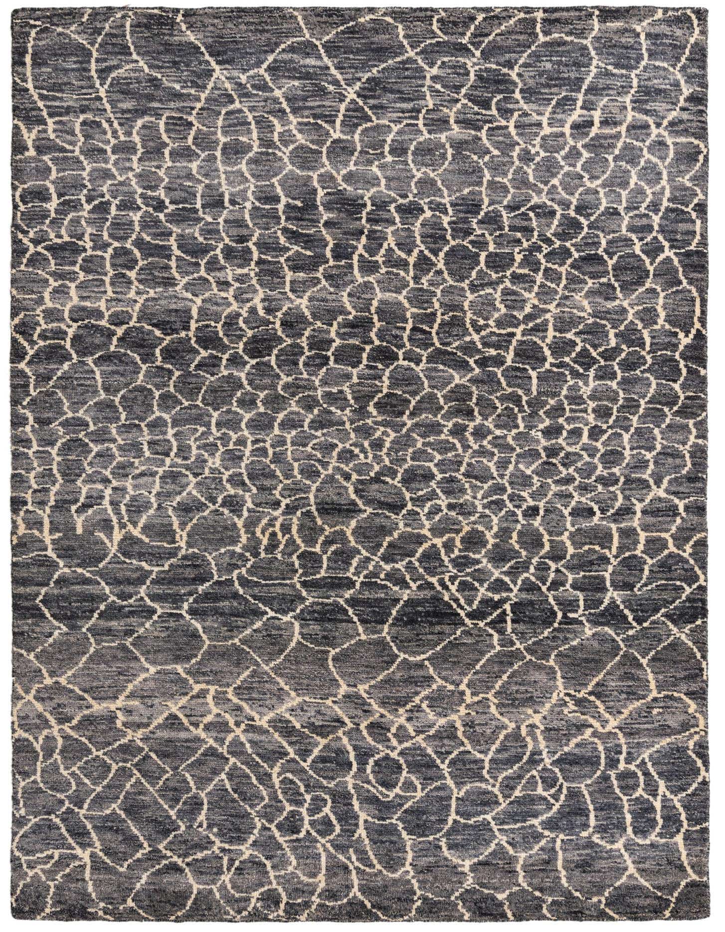 A 5x8 rectangular blue and gray wool shag rug featuring an abstract tribal pattern with light-colored, irregular interlocking shapes.