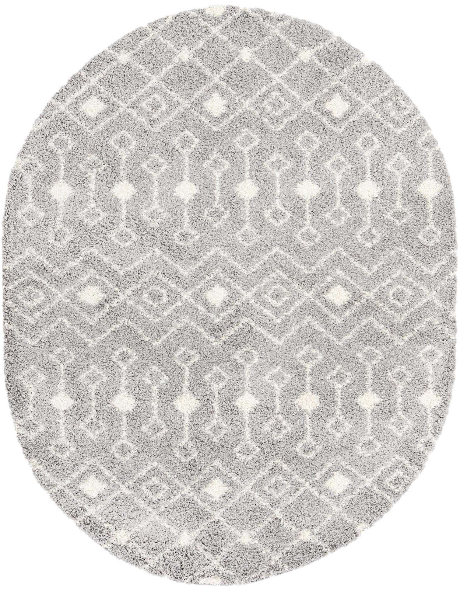 A soft gray oval shag rug with a white tribal geometric pattern, perfect for a modern living room.