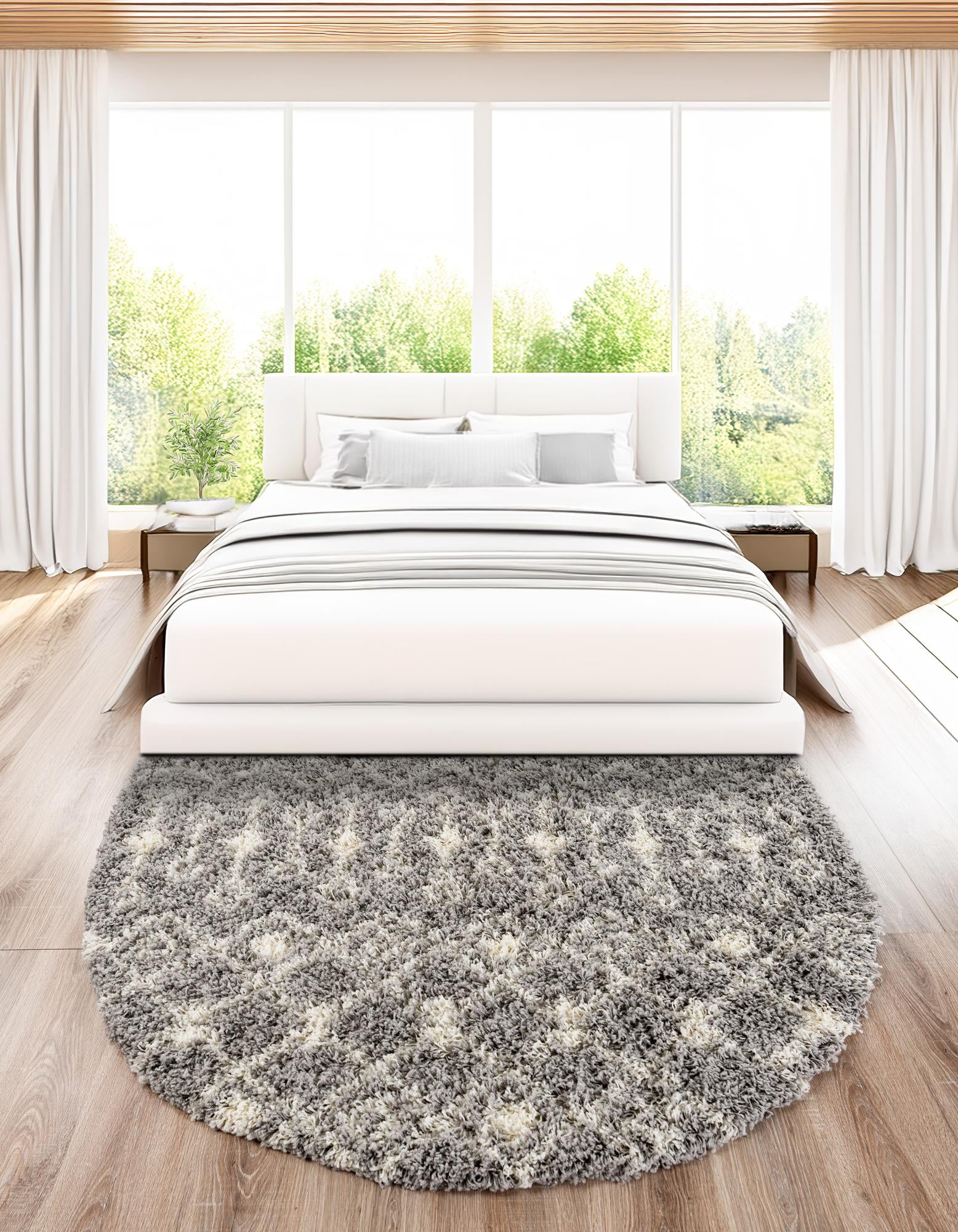 A soft gray oval shag rug with a white tribal geometric pattern, perfect for a modern living room.