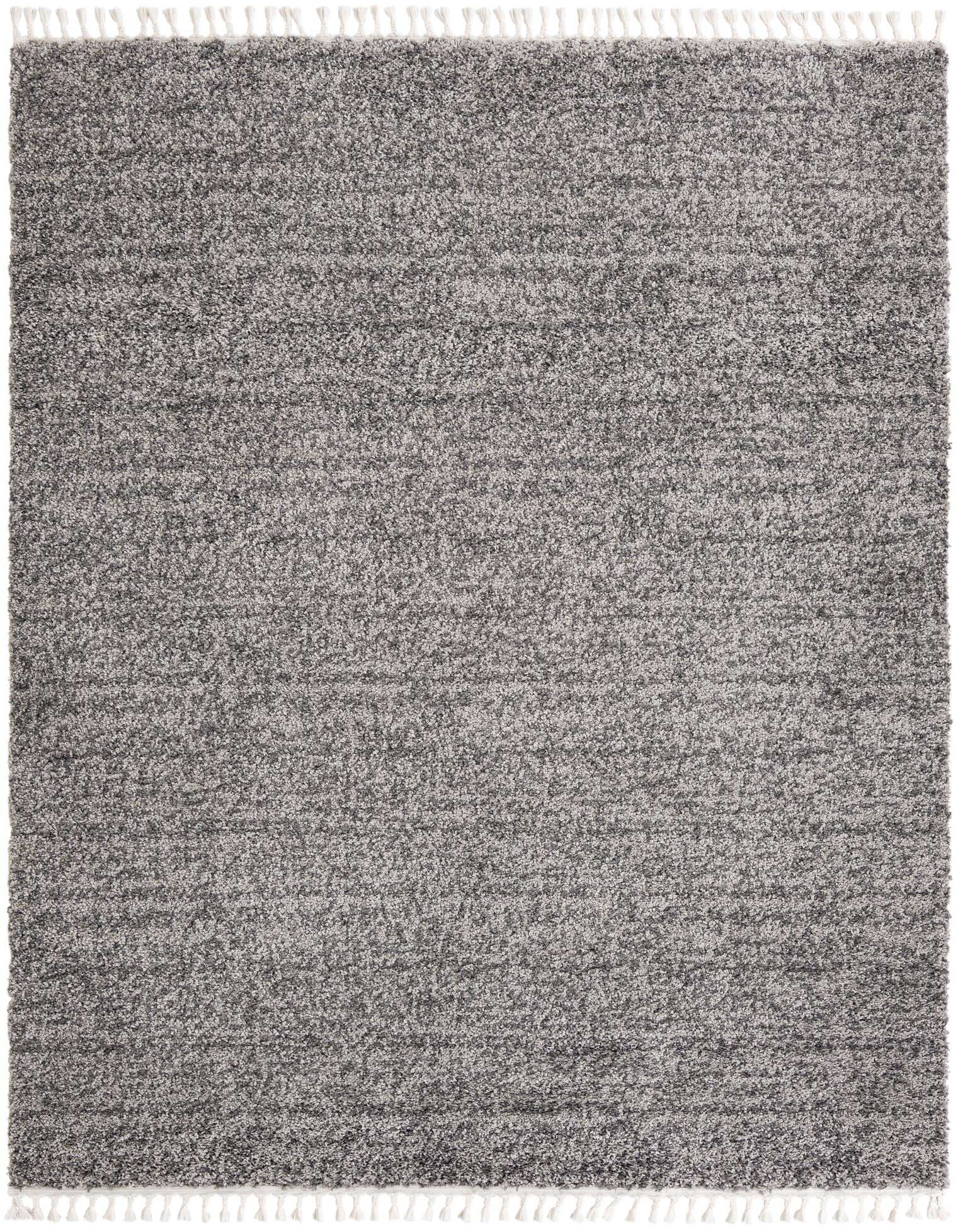 An 8x10 rectangular Athena Shag rug in varying shades of gray, featuring a soft, textured pile and white tassels on two ends.