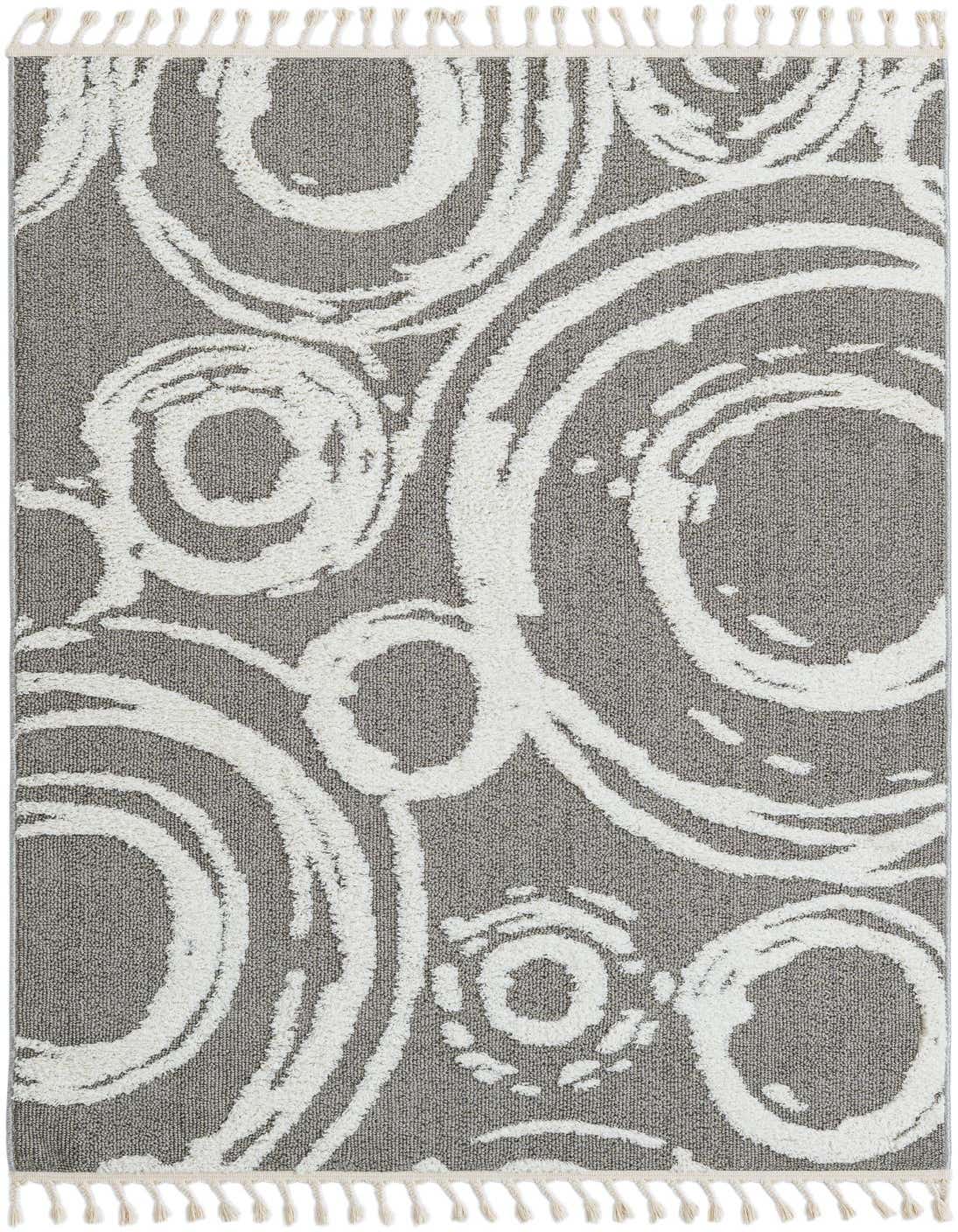 A 5x8 rectangular gray and white abstract bohemian rug with a textured high pile, featuring large white swirling circles and small white tassels on the ends.