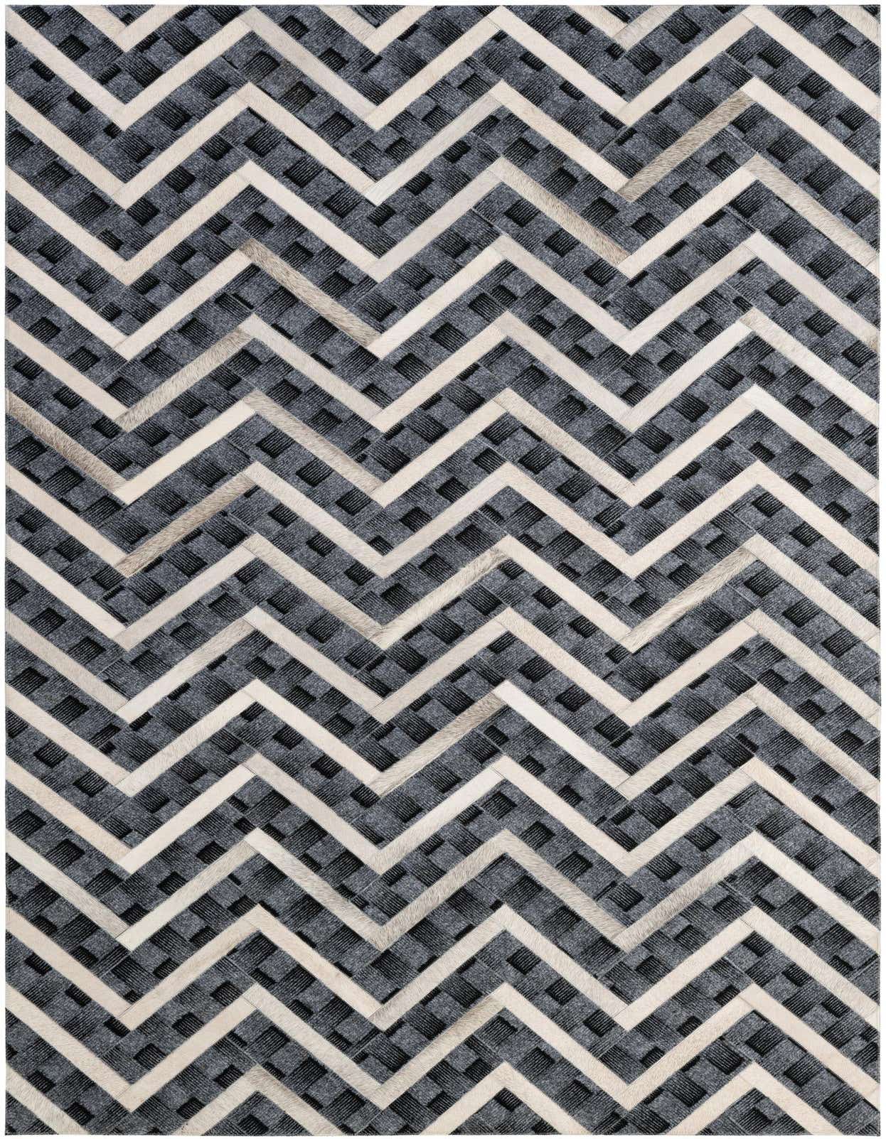 A 5x8 rectangular Cowhide - Patchwork rug featuring a modern chevron pattern in shades of gray and silver.
