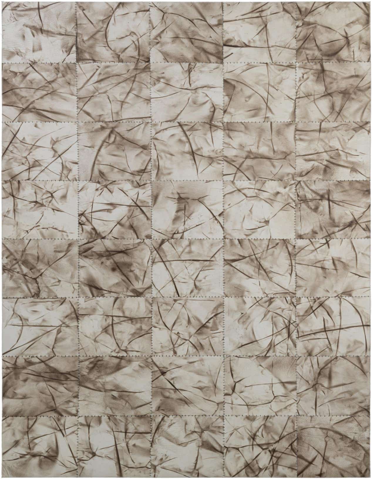 A 5x8 rectangular gray patchwork cowhide rug with an abstract, modern pattern and visible stitching between squares.