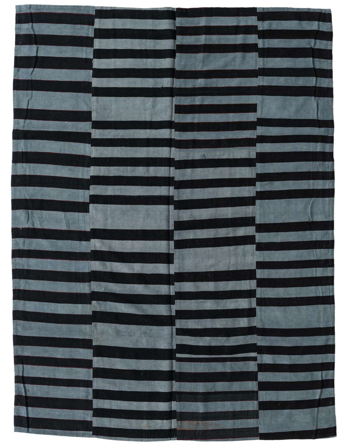 A 5x8 rectangular flatweave rug with a modern patchwork design of alternating gray and black horizontal stripes.