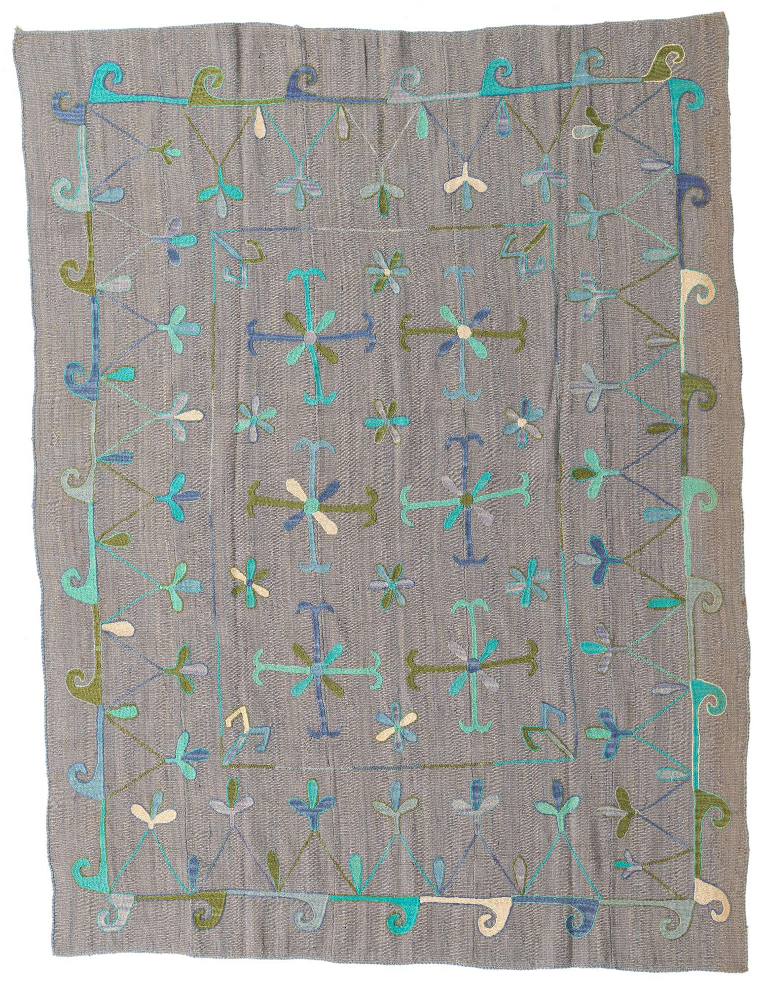 A 5x8 rectangular gray flatweave wool rug with a colorful tribal Suzani pattern in blues, greens, and white.