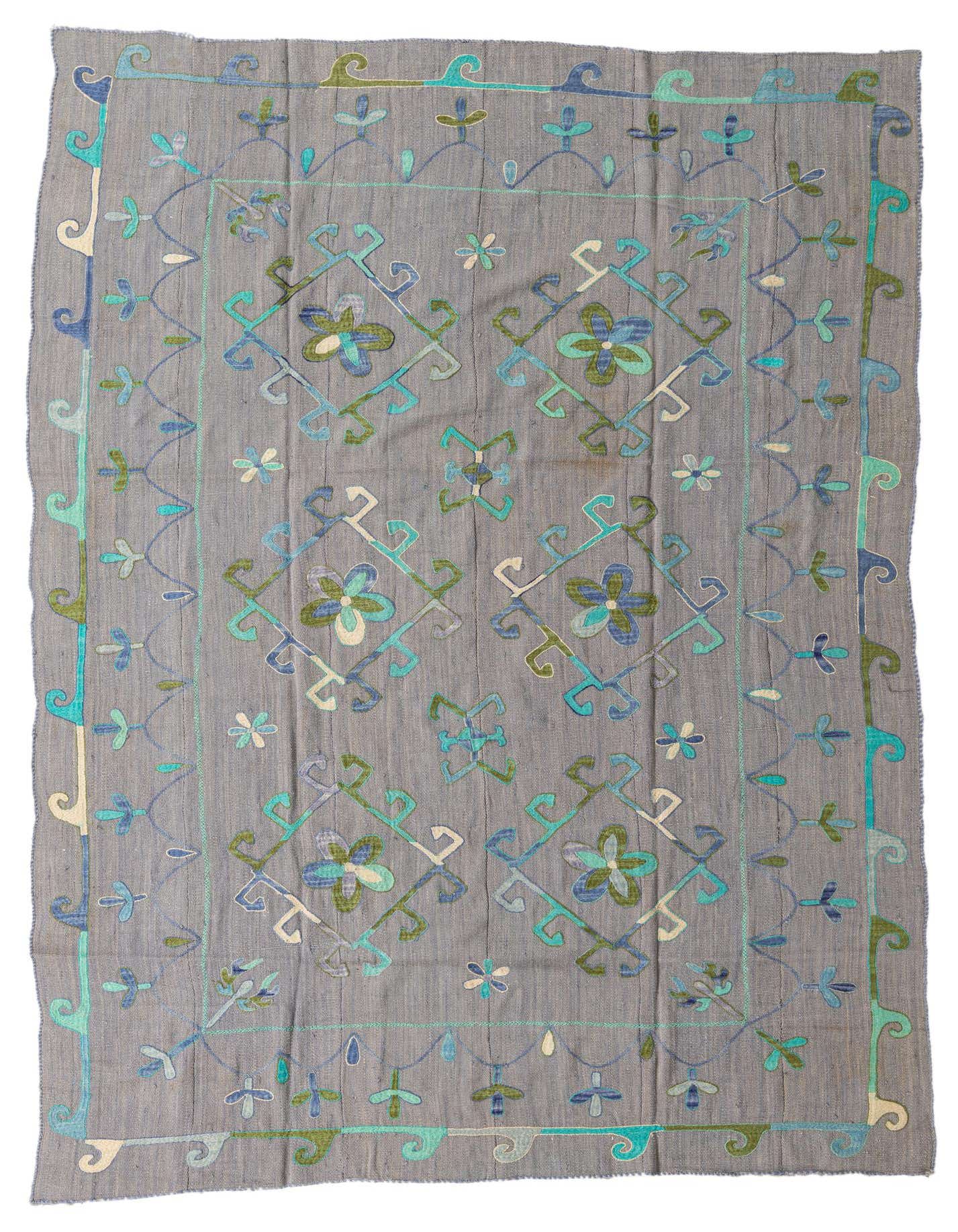 A 7x10 rectangular gray Kilim Suzani rug with tribal floral patterns in shades of blue, green, and cream.