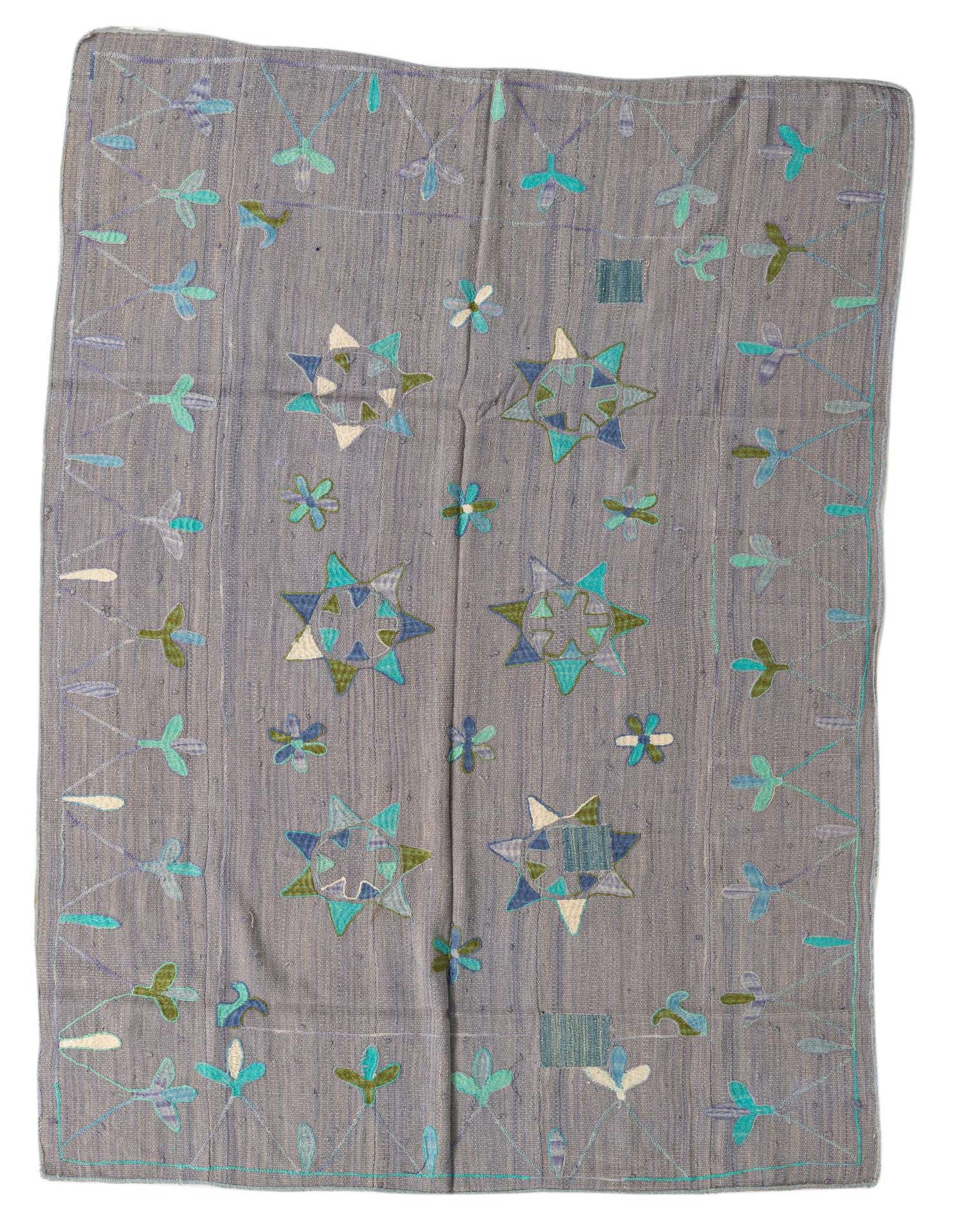A 5x8 rectangular gray Kilim Suzani rug with a flatweave texture, featuring colorful tribal star and floral patterns in blues, greens, and white.