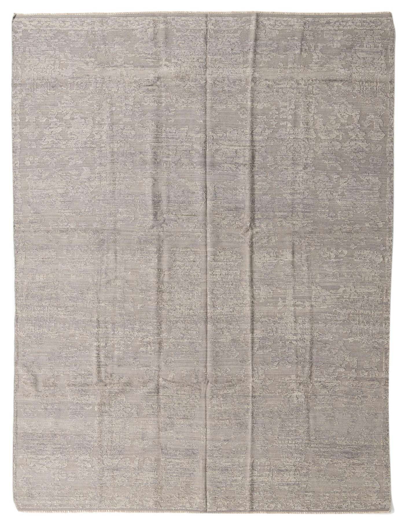 A rectangular 8x12 gray wool shag rug featuring a subtle, abstract tribal pattern, ideal for an indoor living space.