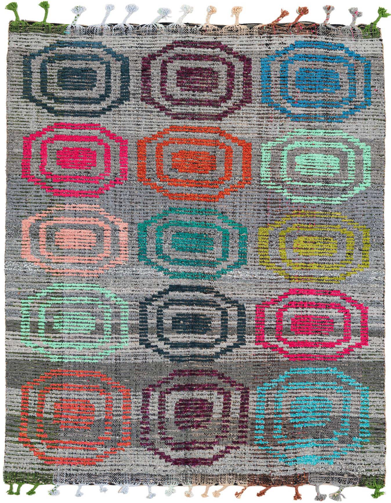 A 5x8 rectangular gray shag rug with a modern tribal pattern of colorful concentric squares in pink, orange, blue, green, and yellow, with multicolored tassels.