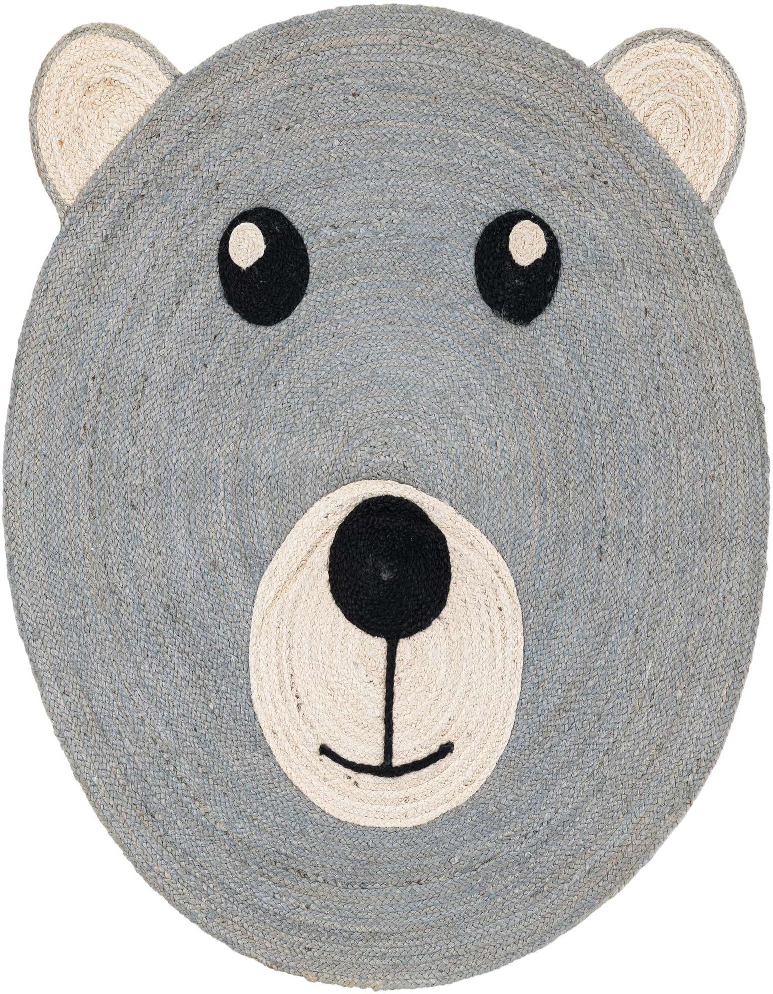 A round gray jute rug shaped like a bear's head with black eyes and nose, and cream-colored snout and ears.