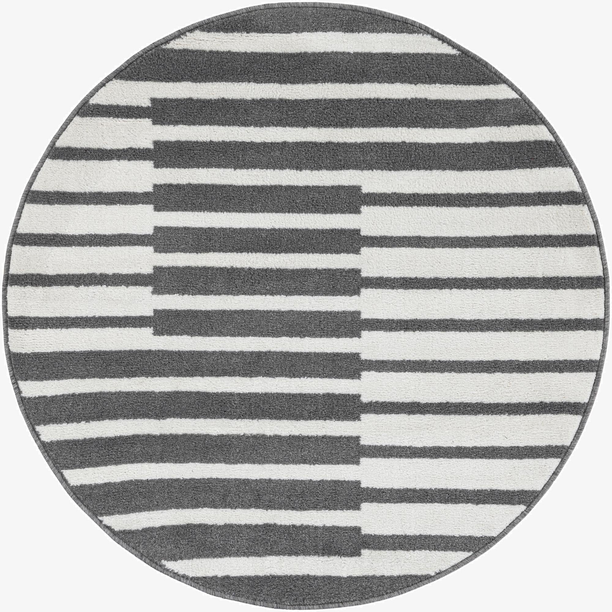 A 4' round gray and white modern rug with horizontal stripes that shift to create a geometric block pattern.