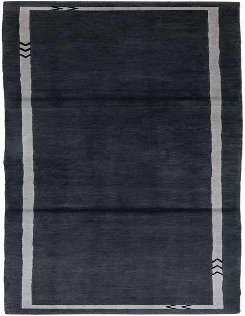 A long, dark gray 11 ft wool runner rug with a light gray border featuring black chevron patterns at the ends.