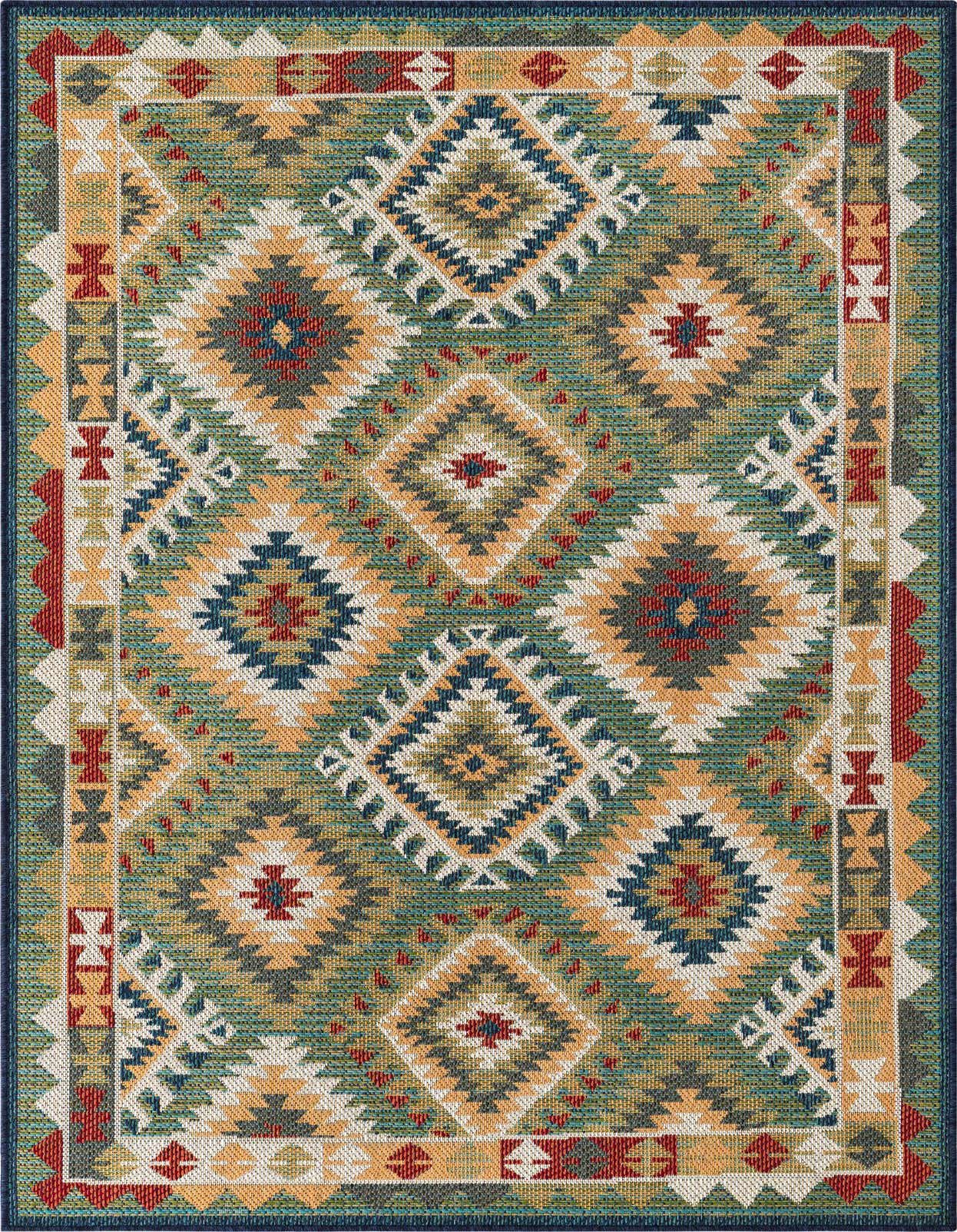A 5x8 rectangular Baja Outdoor rug featuring a vibrant Southwestern tribal pattern in greens, gold, red, and blue.