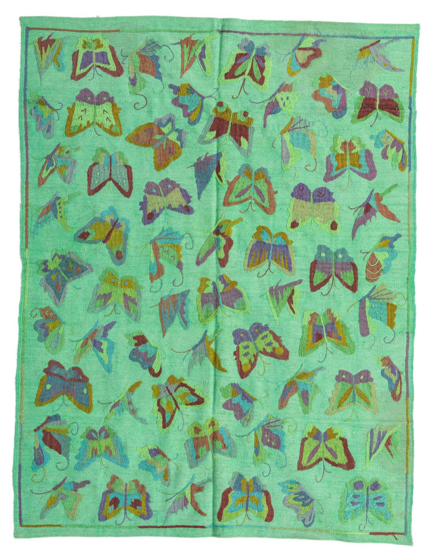 A 4x6 rectangular green flatweave rug with a colorful tribal butterfly pattern, handmade from wool.