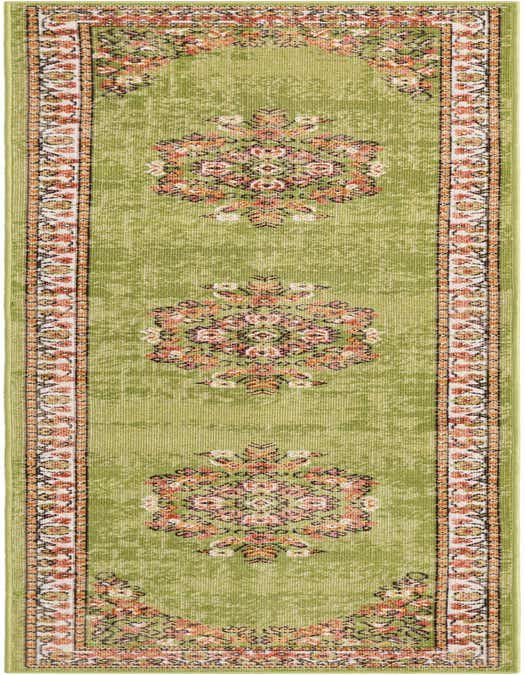 A long 8 ft green runner rug with a distressed look and a traditional floral border in orange, pink, and white.