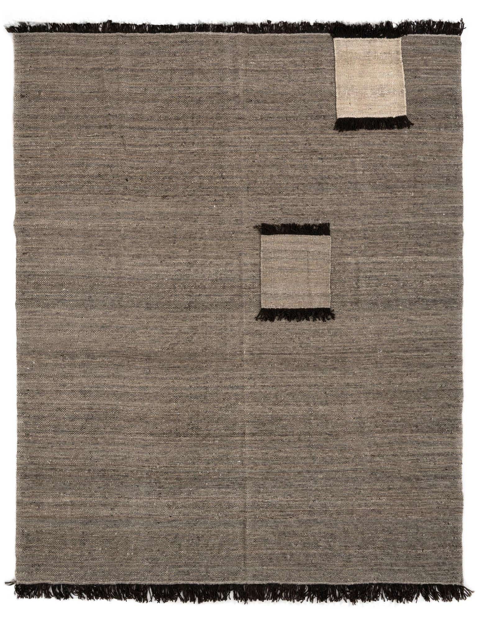 A rectangular 8x10 grey Handweb wool rug with a Persian pattern, featuring two lighter grey patches and dark fringe.