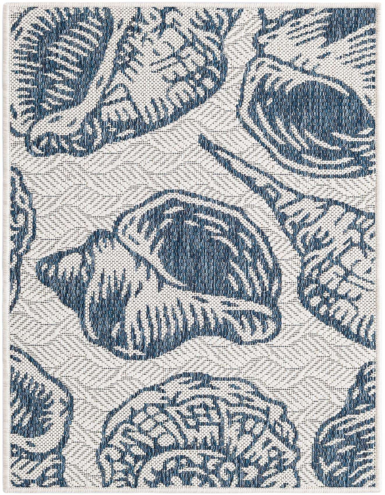 A 2x3 rectangular indoor/outdoor rug featuring a modern coastal pattern of large blue seashells on an ivory background with a subtle chevron texture.