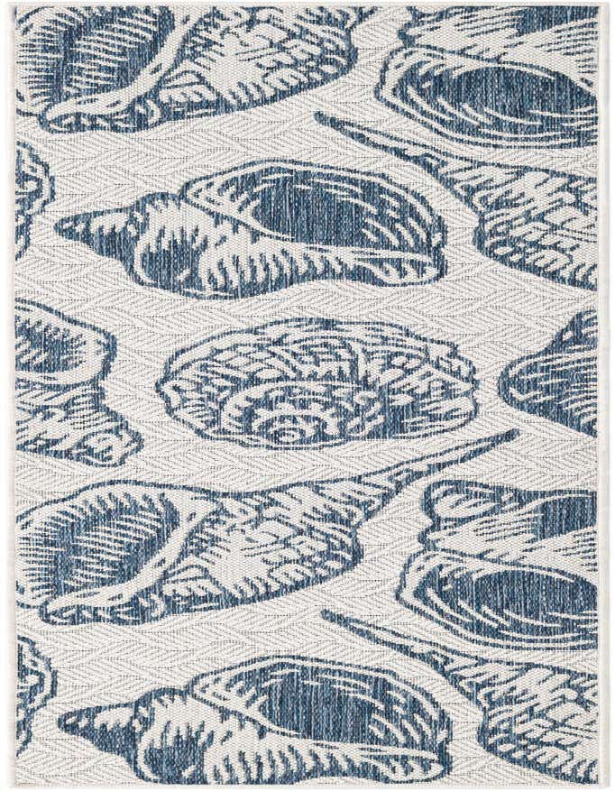 A 6 ft runner rug with a coastal design, featuring large blue seashell patterns on a cream flatweave background, suitable for indoor/outdoor use.