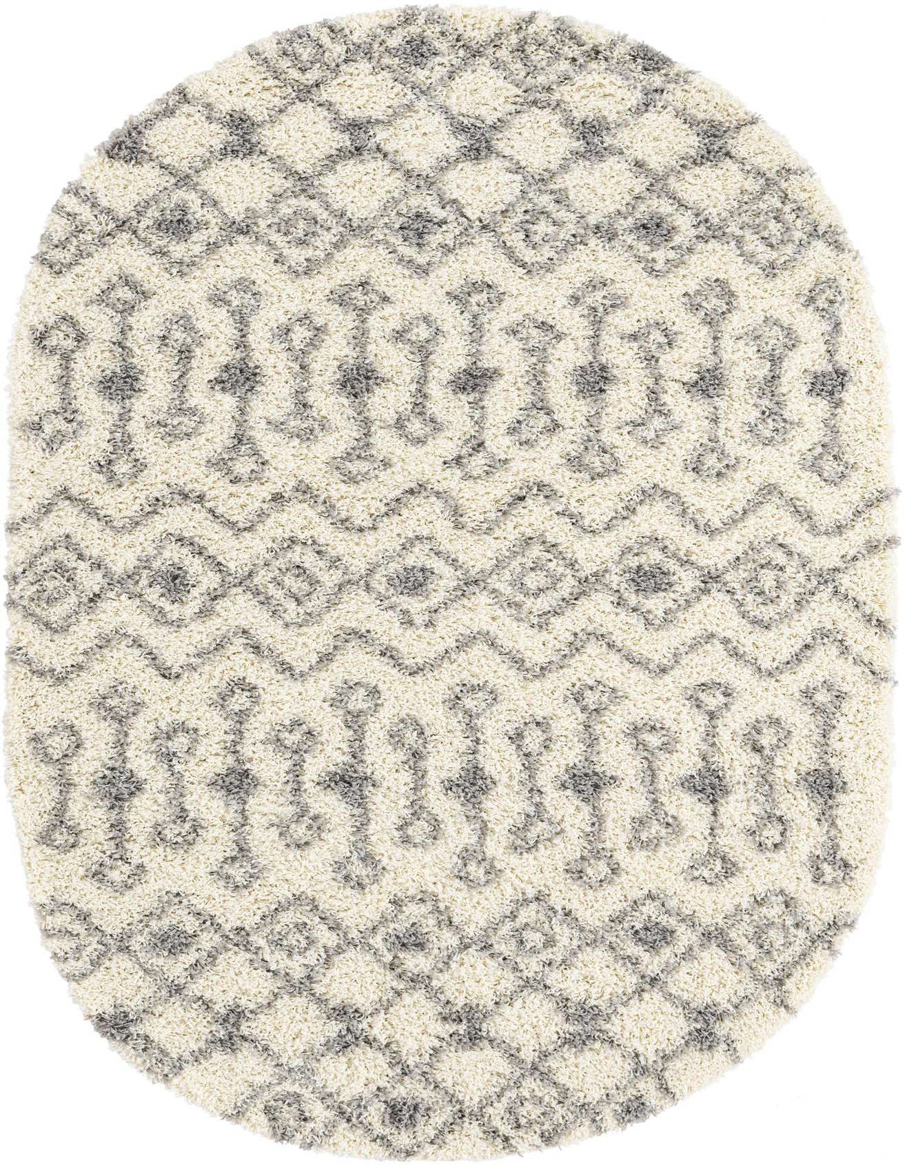 An oval ivory shag rug with a textured gray tribal pattern, featuring diamonds and abstract shapes.