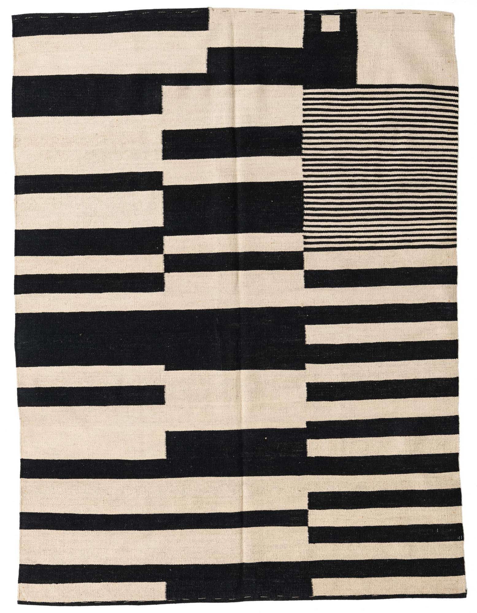 A 5x8 rectangular flatweave rug featuring a bold abstract tribal pattern in black and ivory, suitable for a modern living room.