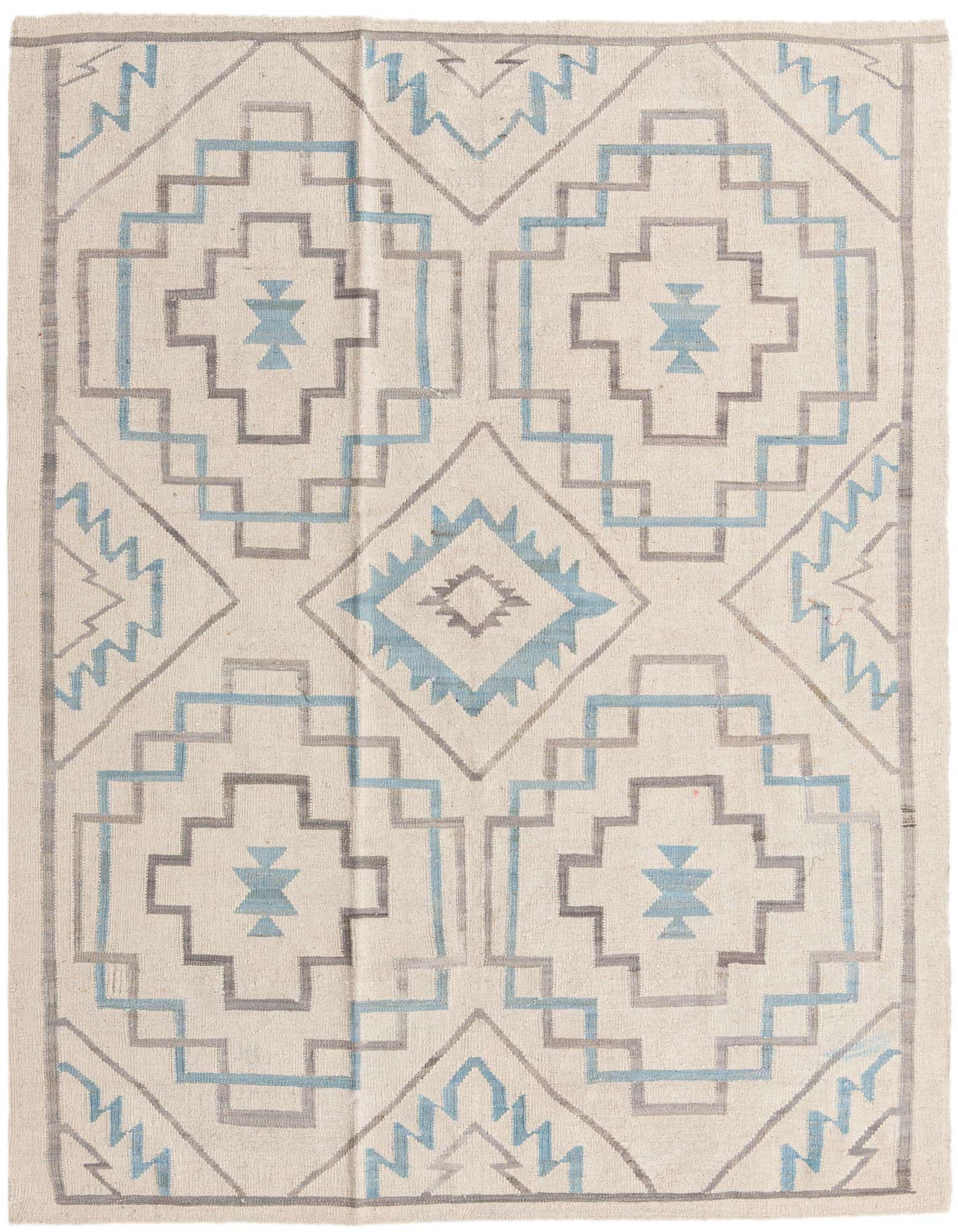 A 6x9 rectangular ivory wool rug with a tribal geometric pattern in light blue and grey, perfect for a modern living room.