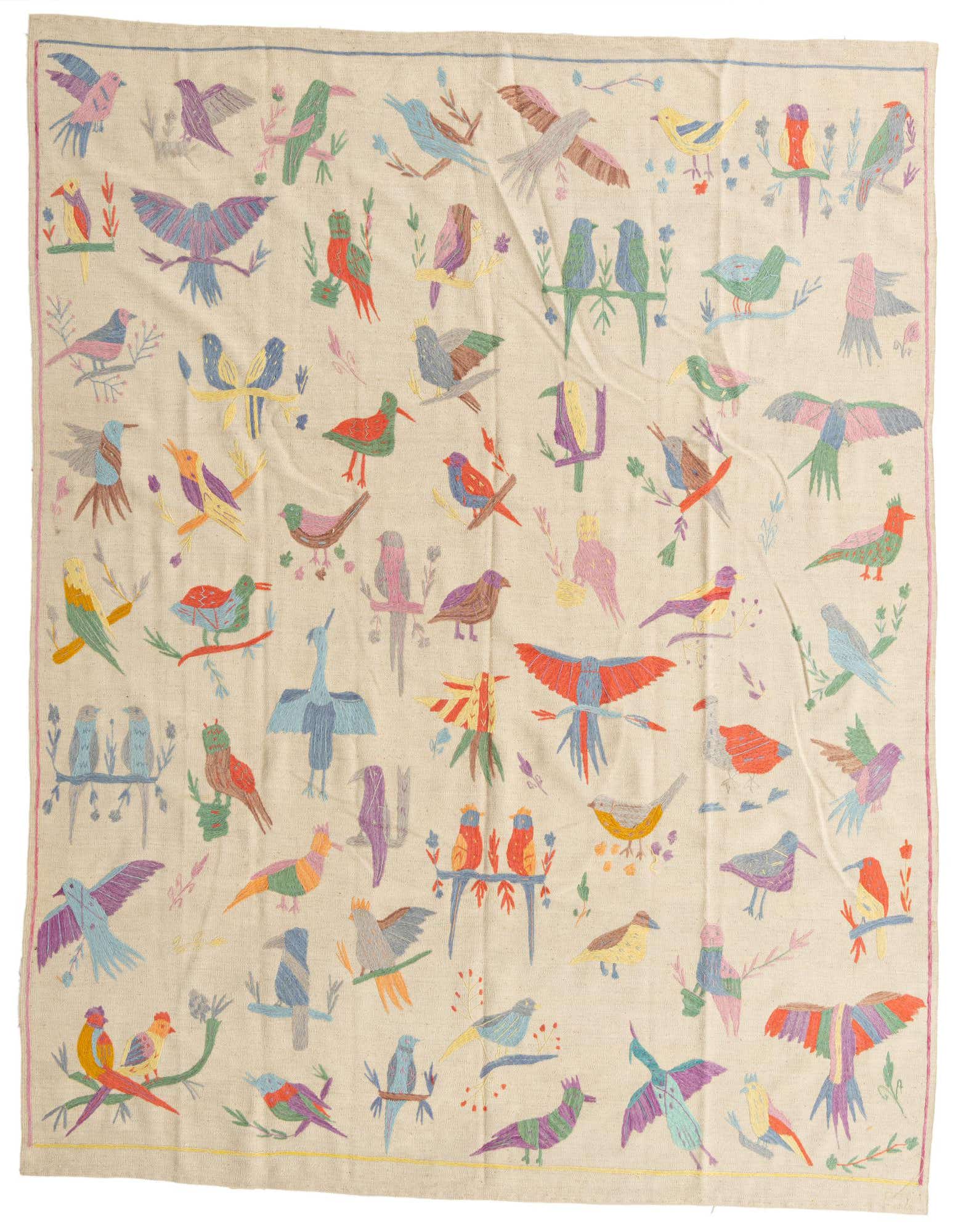An 8x10 rectangular ivory flatweave rug with a vibrant, colorful tribal bird and floral pattern, handmade from wool.