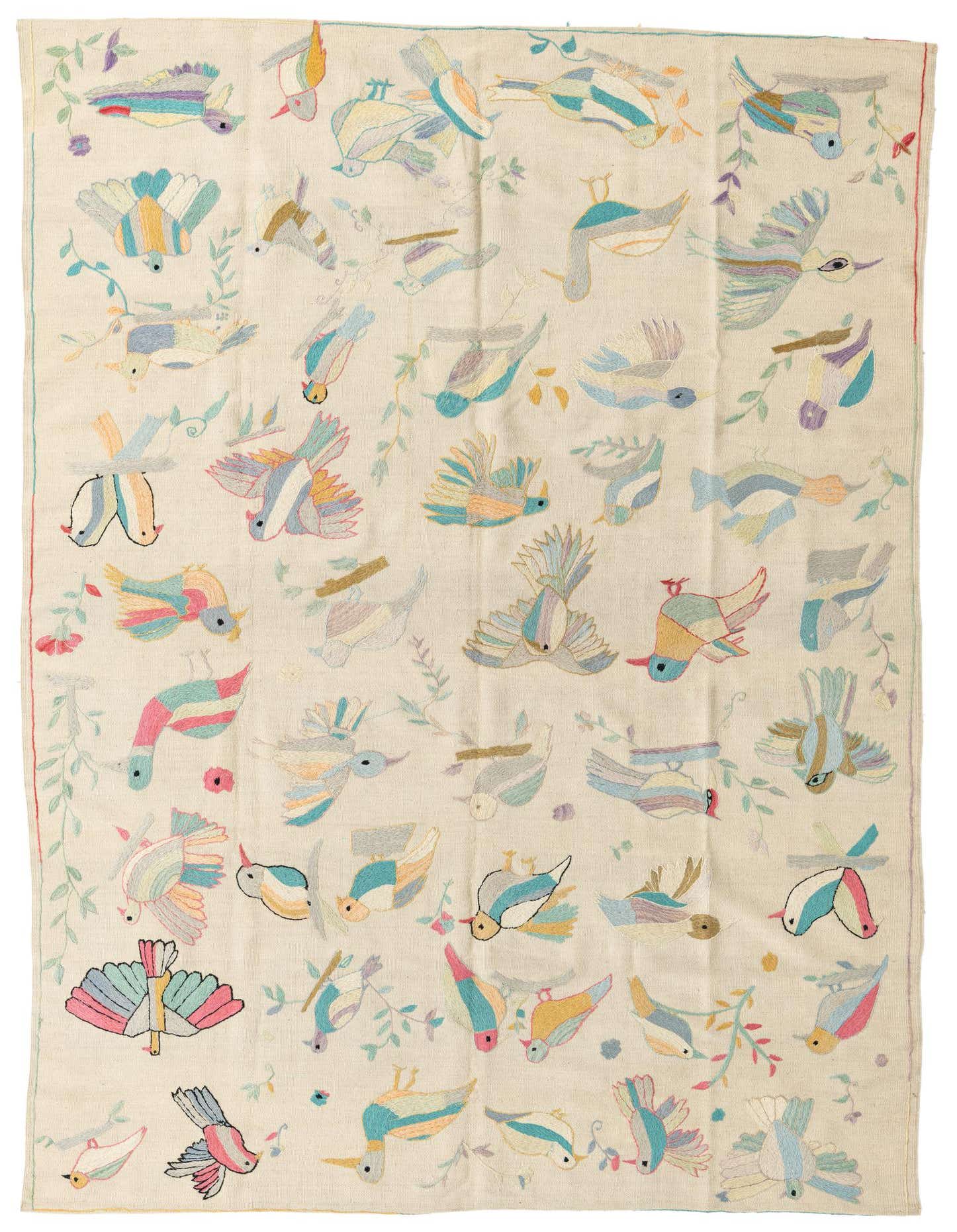 A 6x9 rectangular ivory flatweave rug featuring a vibrant, whimsical pattern of colorful birds and delicate floral vines, perfect for a living room.