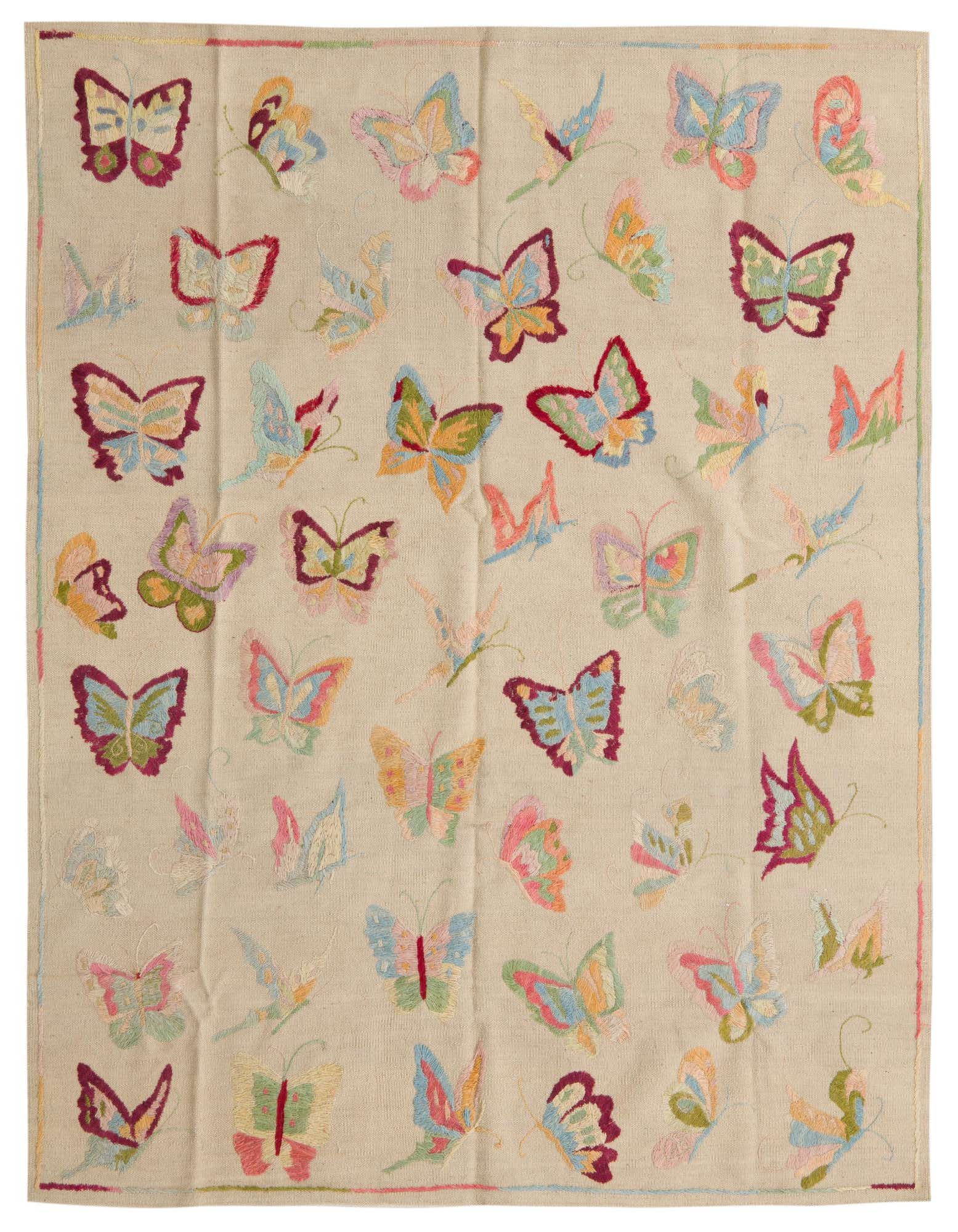 A 4x6 ivory flatweave wool rug with a vibrant, scattered butterfly pattern in various colors like blue, pink, green, and orange.